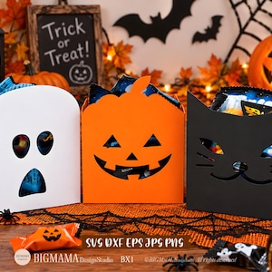 Może przedstawiać: Trzy pudełka na słodycze na Halloween w kolorze białym, pomarańczowym i czarnym. Białe pudełko ma kształt ducha, pomarańczowe przedstawia twarz dyni, a czarne ma wzór kociego pyszczka. Każde pudełko jest wypełnione różnymi rodzajami słodyczy.