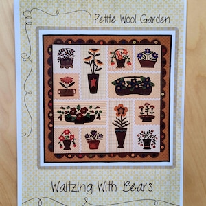 May include: A brochure titled "Petite Wool Garden" by "Waltzing With Bears" features a patchwork design of various potted flowers in shades of red, brown, and blue. The brochure has a cream-colored background with a yellow floral pattern.