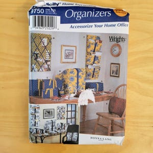 May include: A sewing pattern for home office organizers. The pattern features various designs, including fabric-covered boxes, wall organizers, and desk accessories. The image shows a finished product with a yellow and blue floral pattern.