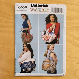 May include: A Butterick Waverly sewing pattern, B5658, featuring four tote bag designs. The bags showcase various floral and paisley prints in red, blue, and beige. The pattern includes the text "WAVERLY" and "ONE SIZE/UNE SEULE TAILLE".