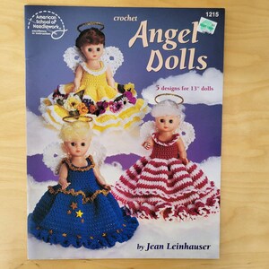 May include: A crochet pattern book titled "Angel Dolls" featuring three dolls in handmade dresses. The cover shows dolls with halos and wings, each in a different colored dress. The book is by Jean Leinhauser and includes 5 designs for 13-inch dolls.