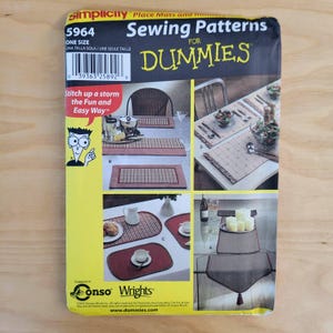 May include: A Simplicity sewing pattern for place mats and runners. The package features images of finished place mats and table runners. The text includes "Sewing Patterns for Dummies" and "Stitch up a storm the Fun and Easy Way."
