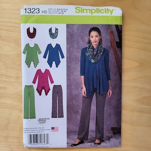 May include: Simplicity sewing pattern 1323 features a woman wearing a blue top and gray pants. The pattern includes options for tops and pants. The pattern size is US 6, 8, 10, 12, and 14.