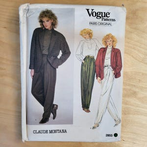 May include: Vogue Patterns sewing pattern featuring a woman in a blazer and pleated pants. The pattern is by Claude Montana. The cover has the Vogue Patterns logo and the words "Paris Original". The pattern number is 2853.