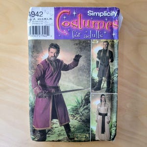 May include: Simplicity costume pattern for adults, featuring a medieval-style outfit with a long burgundy coat and sword. The pattern includes sizes XS to XL. The package has a purple and gold design.