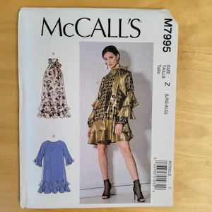 May include: McCall's sewing pattern M7995 featuring three dress designs. The main image showcases a gold and black patterned dress with ruffles. The pattern includes sizes LRG-XLG. The McCall's logo is at the top.