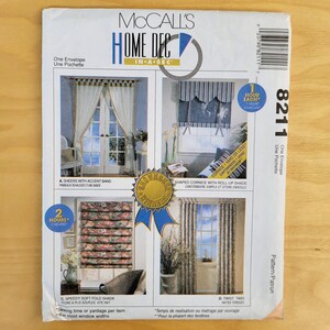 May include: McCall's Home Dec sewing pattern envelope featuring four window treatment designs: sheers, a shaped cornice, a soft fold shade, and twist tabs. The envelope is white with blue and gold accents and includes the number 8211.