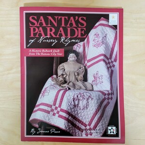 May include: A book titled "Santa's Parade of Nursery Rhymes" featuring a redwork quilt with embroidered images of Santa and other holiday figures. The book is a project book for making a quilt based on a historic quilt from the Kansas City Star.