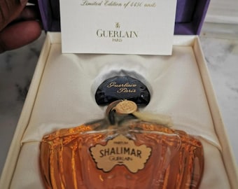 May include: A 30 ml bottle of Shalimar perfume in a Baccarat crystal bottle. The bottle is in a purple box with a gold label that reads "Shalimar 30 ml Parfum bottle Numbered Baccarat crystal collection Limited Edition of 4450 units Guerlain Paris".