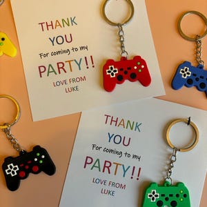 以下が含まれることがあります： カラフルな「ありがとう」メッセージと「Love from Luke」のテキストが書かれた4枚のサンキューカード。各カードには、小さなカラフルなプラスチック製ビデオゲームコントローラーキーホルダーが付属しています。