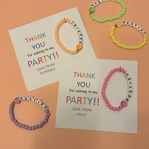 May include: Four thank you cards with the text "Thank You for coming to my party!" and the name of the host. Each card has a colourful beaded bracelet with the word "Besties" spelled out on it.