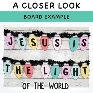Op de afbeelding: Een decoratieve banner met de tekst "JESUS IS HET LICHT VAN DE WERELD" op kleurrijke lampvormige uitsparingen. De banner is gespannen tegen een witte houten achtergrond, met zwarte slingers.