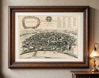 May include: A framed historical map of Vienna, Austria, featuring a detailed black and white bird's-eye view of the city with fortifications, a decorative title cartouche, and a numbered legend, all enclosed in a dark brown wooden frame.