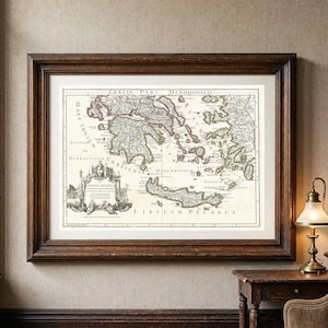 Puede incluir: Un mapa de estilo antiguo titulado Gracia Pars Meridionalis que representa el sur de Grecia y las islas circundantes, enmarcado en un marco de madera oscura con un paspartú color crema. El mapa presenta tinta negra sobre un fondo claro.