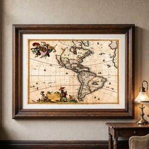 Puede incluir: Un mapa antiguo enmarcado de las Américas sobre un fondo de pergamino beige con líneas de costa y cuadrículas en tinta negra, junto a ilustraciones decorativas de figuras y barcos, dentro de un marco de madera de color marrón oscuro.