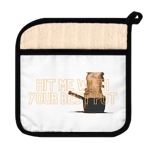 Puede incluir: Un agarrador de olla blanco con ribete negro y una olla marrón con vapor saliendo de ella. El texto "HIT ME WITH YOUR BEST POT" está escrito en naranja.