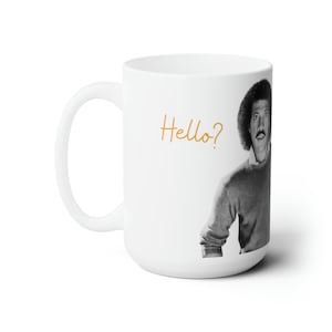 May include: White ceramic mug featuring a black and white image of a man with an afro, looking over his shoulder and saying "Hello?" in orange text.