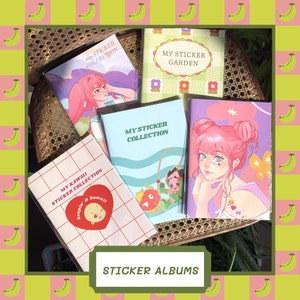 May include: Several sticker albums with colourful covers, each displaying anime-style artwork and text. The albums, in shades like pink and blue, are arranged on a woven surface. The words "STICKER ALBUMS" are displayed at the bottom of the image.
