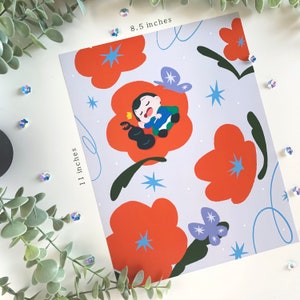 May include: An 8.5 by 11 inch print featuring a cartoon illustration of a person sleeping in a flower. The background is a light blue with orange flowers and stars.