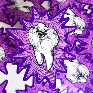Può includere: Un adesivo con un'illustrazione di dente bianco e contorni neri, su un design a scoppio viola. L'adesivo ha un bordo frastagliato e si ripete su una superficie bianca. Il design è audace e grafico.