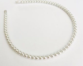 May include: A thin, flexible headband covered in a continuous row of small, polished silver-toned spherical beads. The accessory features a rounded, semi-circular shape with smooth, tapered end caps at both tips, creating a uniform metallic appearance.