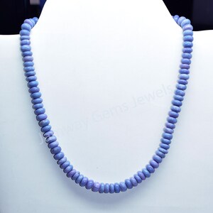 May include: A light blue gemstone necklace made of round beads. The necklace is on a white mannequin bust.
