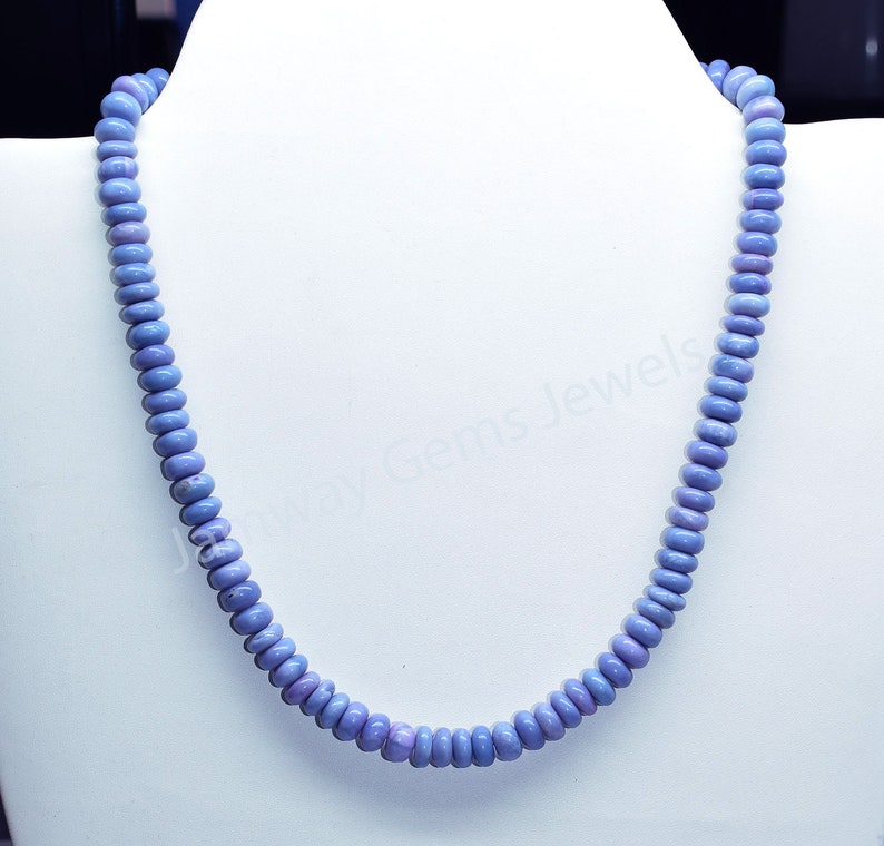 May include: A light blue gemstone necklace made of round beads. The necklace is on a white mannequin bust.
