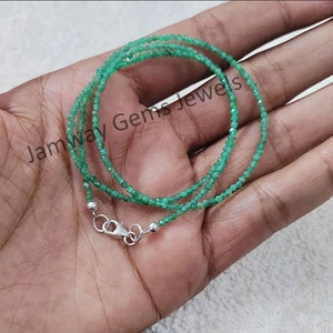 May include: A green gemstone necklace with a silver clasp. The necklace is made of small, faceted beads and is approximately 18 inches long.