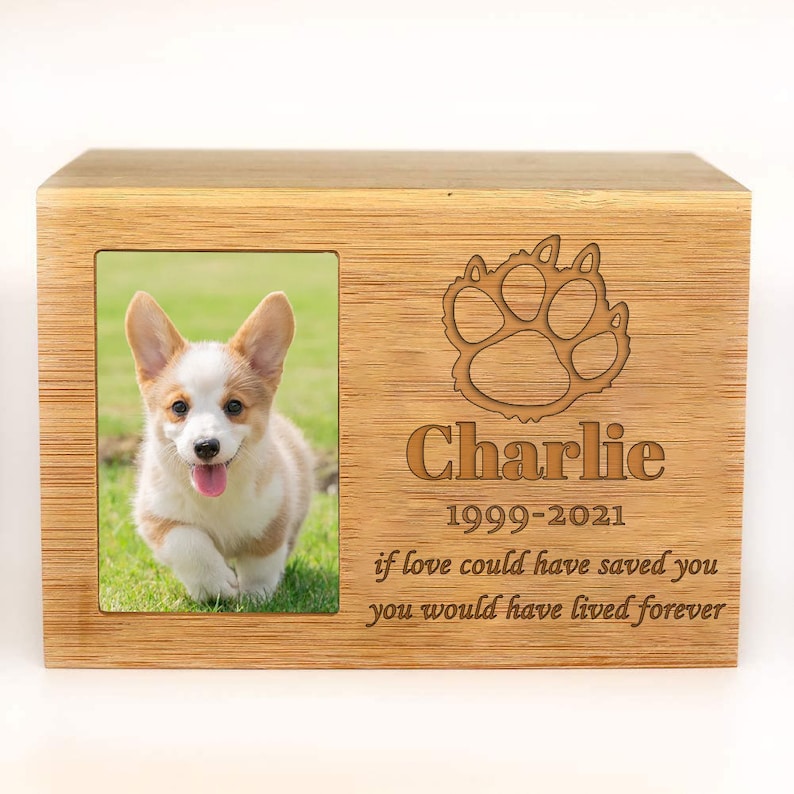 Peut inclure: Bo&icirc;te comm&eacute;morative en bois pour animaux de compagnie avec un cadre photo et un motif de patte. La bo&icirc;te est grav&eacute;e du nom "Charlie" et des dates "1999-2021". Le texte "si l'amour avait pu te sauver, tu aurais v&eacute;cu pour toujours" est &eacute;galement grav&eacute; sur la bo&icirc;te.