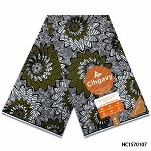 May include: A folded piece of fabric featuring a repeating pattern of large, stylized olive green and white spiral flowers on a dark gray background with a fine white geometric web design. An orange circular label reads Cihgavy and Cottonhaus.