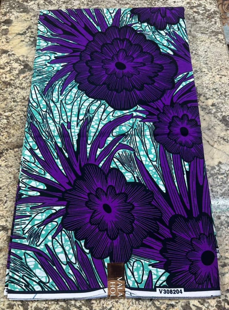 May include: A rectangular piece of fabric featuring a vibrant pattern of large, dark purple flowers with black outlines. The background consists of a teal and white marbled or crackled design, interspersed with long, dark purple, pointed leaves.