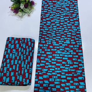 May include: A length of fabric and a folded square of the same material, both featuring a repeating geometric pattern of bright cyan rectangles and small dark blue circles set against a deep maroon background, accompanied by a small floral bouquet.