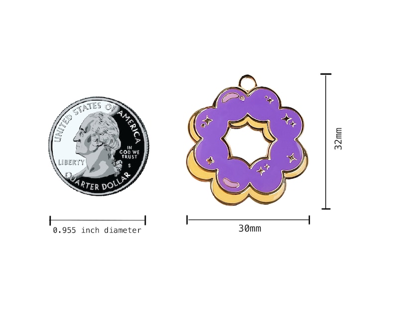 K&ouml;nnte beinhalten: Ein lila-gelber Donut-Anh&auml;nger aus Emaille mit goldener Oberfl&auml;che. Der Anh&auml;nger ist 30 mm im Durchmesser und 32 mm hoch.