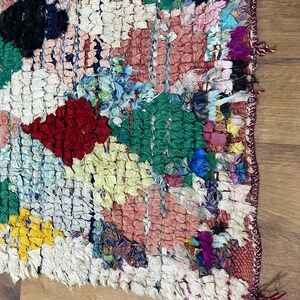 Puede incluir: Una alfombra colorida tejida a mano con un dise&ntilde;o de patchwork. La alfombra est&aacute; hecha de varias telas en tonos de rojo, verde, azul, amarillo y blanco. La alfombra tiene un borde deshilachado y est&aacute; hecha con un tejido texturizado &uacute;nico.