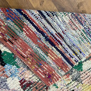 Puede incluir: Una alfombra de trapo colorida con un dise&ntilde;o de patchwork. La alfombra est&aacute; hecha de diferentes telas de colores que se han tejido juntas. La alfombra tiene un aspecto r&uacute;stico y vintage.