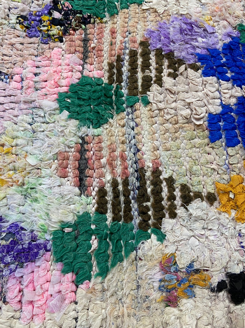 Puede incluir: Una alfombra colorida tejida a mano con un dise&ntilde;o de patchwork. La alfombra presenta varios colores, incluyendo rosa, verde, azul y blanco. La alfombra est&aacute; hecha de materiales reciclados y tiene una superficie texturizada &uacute;nica.