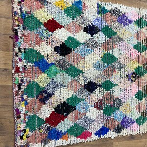 Puede incluir: Una alfombra marroqu&iacute; colorida con un patr&oacute;n de diamantes. La alfombra est&aacute; hecha de lana y tiene una variedad de colores, incluyendo rojo, verde, azul y blanco.