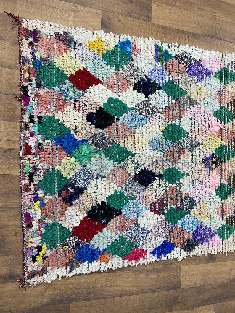 Puede incluir: Una alfombra marroqu&iacute; colorida con un patr&oacute;n de diamantes. La alfombra est&aacute; hecha de lana y tiene una variedad de colores, incluyendo rojo, verde, azul y blanco.