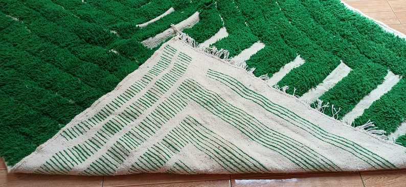 May include: A green and white striped rug with a fluffy texture. The rug is folded in half, showing both sides of the pattern.