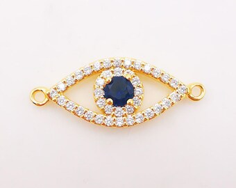May include: Gold evil eye charm with a blue center stone and clear crystal accents.