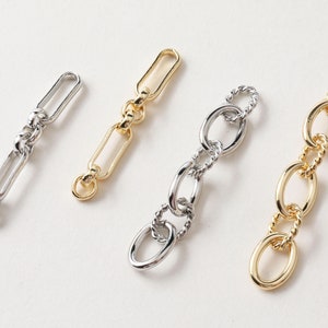 Puede incluir: Cuatro eslabones de cadena diferentes en plata y oro. Las cadenas son de diferentes estilos, algunas son más gruesas y otras más finas. Las cadenas tienen todas aproximadamente la misma longitud.