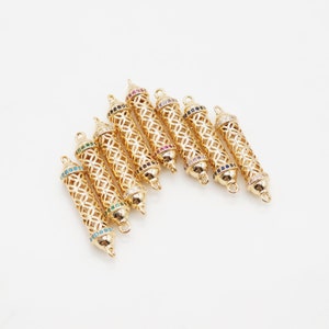 May include: Eight gold-toned metal pendant charms with intricate openwork designs and colourful crystal accents. The charms are cylindrical in shape and have a loop at the top for attaching to a necklace or bracelet.