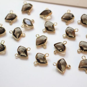 K&ouml;nnte beinhalten: Eine Sammlung von 18 goldfarbenen Edelstein-Verbindungselementen mit einem facettierten, tropfenf&ouml;rmigen Design. Die Verbindungselemente haben zwei &Ouml;sen auf der R&uuml;ckseite zum Anbringen an Schmuck.