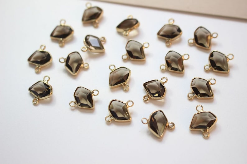 K&ouml;nnte beinhalten: Eine Sammlung von 18 goldfarbenen Edelstein-Verbindungselementen mit einem facettierten, tropfenf&ouml;rmigen Design. Die Verbindungselemente haben zwei &Ouml;sen auf der R&uuml;ckseite zum Anbringen an Schmuck.