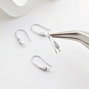 May include: Silver earring hooks with clear cubic zirconia stones. The hooks are designed to be used with jewelry making supplies.