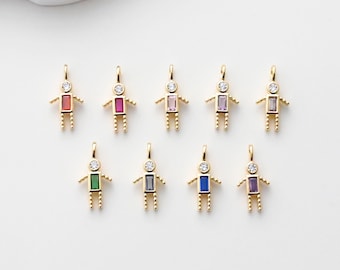 May include: Gold-toned pendant charms in the shape of stick figures, each with a different colored rectangular gemstone body. The charms have small arms and legs, and a clear gemstone head. The charms are displayed on a white surface.