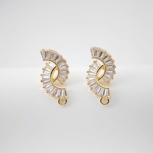 Może przedstawiać: Para złotych kolczyków w kształcie półksiężyca, ozdobionych przezroczystymi cyrkoniami.