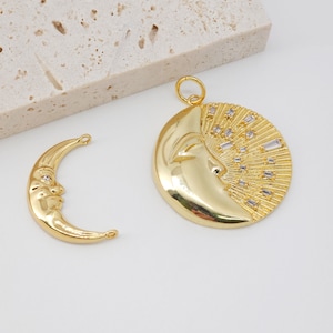 May include: Two gold-tone metal crescent moon charms with a face design. One charm has a face with a single rhinestone eye and the other charm has a face with a single rhinestone eye and a halo of rhinestones.