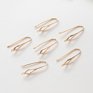 Puede incluir: Seis ganchos para pendientes de color dorado con una abertura en forma de diamante en la parte superior. Los ganchos están diseñados para sujetar pendientes.