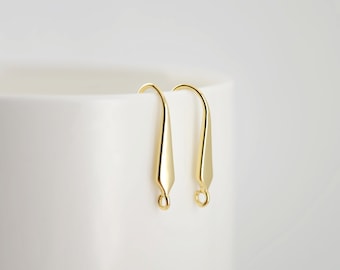 May include: A pair of gold-toned earring hooks with a teardrop-shaped design.